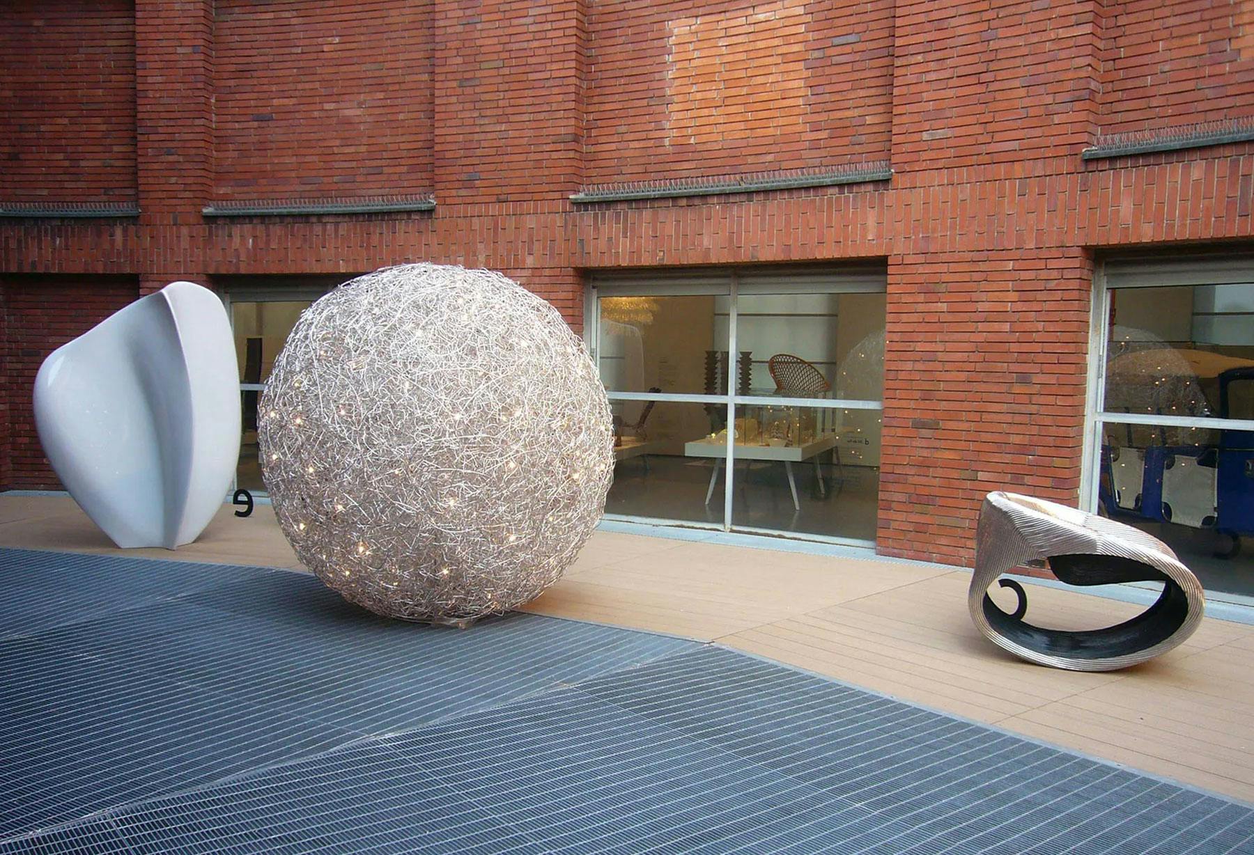 <p>En la Trienal de Milán, para la «Mostra Triennale Serie Fuori», aparece una enorme madeja de alambre de aluminio, que contiene muchos puntos luminosos, una lámpara cósmica que parece un posible modelo del universo.</p>
